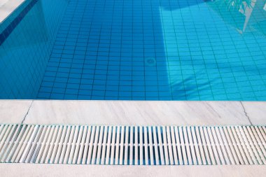 Mavi sökük su kaldırım kenarına tropikal Resort yüzme havuzunda. Yüzme Havuzu alt arka planın parçası. Açık ışık mavi havuz suyu güneş yansıması ile dalgaların. Yüzey Yüzme Havuzu.