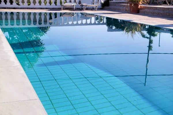 Плавательный бассейн дизайн современной архитектуры роскошной виллы отдыха. Отдохните у экзотического бассейна с перилами, шезлонгами, шезлонгами и зонтиками в тропическом курортном отеле . — стоковое фото