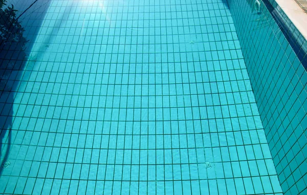 Les causes du fond de la piscine ondulent et coulent avec le fond des vagues. Surface de la piscine bleue, fond d'eau dans la piscine. Clair lumière bleu piscine ondulations d'eau avec des reflets de soleil . — Photo