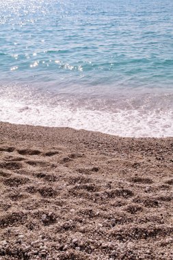 Egzotik kumlu plaj, tropikal mavi Akdeniz deniz dalgalar ve deniz köpüğü ile. Güzel doğal ortamı, panorama, manzara. Yaz sezonunda, cennet ve şaşırtıcı sahne sakin tatil beldesi.