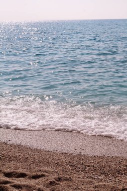 Egzotik kumlu plaj, tropikal mavi Akdeniz deniz dalgalar ve deniz köpüğü ile. Güzel doğal ortamı, panorama, manzara. Yaz sezonunda, cennet ve şaşırtıcı sahne sakin tatil beldesi.