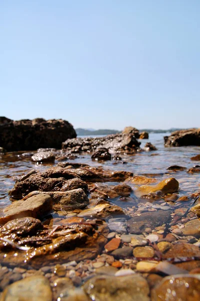 Exotisch rotsachtig strand met kleurrijke stenen, tropische blauwe zee met golven en schuim. Prachtige natuurlijke omgeving, Panorama, landschap. Idyllische badplaats in het zomerseizoen, paradijs, verbazingwekkende scène. — Stockfoto