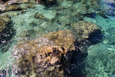 Deniz kıyısı ve kayalar, kayalık kıyı şeridi, mavi deniz, iyi güneşli bir gün ile plaj. Yaz gezisi. Güzel Yunanistan. En güzel plaj, doğal çevre, dalgalar ve tropikal manzara, ufuk ve Panorama.