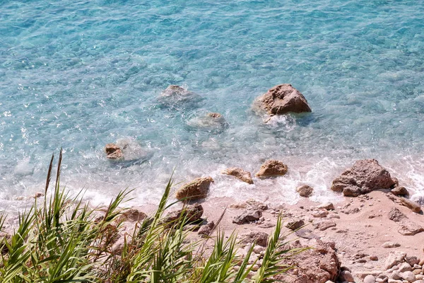 Costa de mar y playa con rocas, costa rocosa, mar azul, buen día soleado. Viaje de verano. Hermosa Grecia. Playa más hermosa, entorno natural, olas y paisaje tropical, horizonte y panorama . —  Fotos de Stock