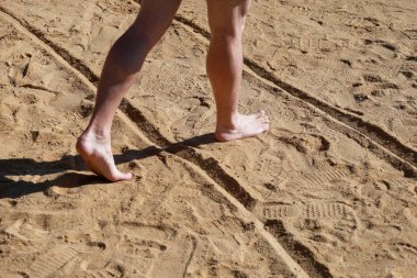 Kumda erkek bacakları. Erkek ayakları Mısır'da Kızıldeniz'de otel tesisi güzel kumlu plajda yürüyüş yapıyor ve kum ayak izleri geride bırakın. Yaz ları tatilde olan adam. Seyahat ve tatil konsepti.