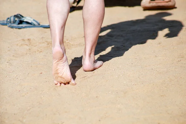 Jambes d'homme sur sable. Pieds masculins marchant sur la belle plage de sable fin de la station hôtelière sur la mer Rouge en Egypte, faire et laisser des empreintes de pas dans le sable. Homme en vacances en été. Concept de voyage et vacances . — Photo