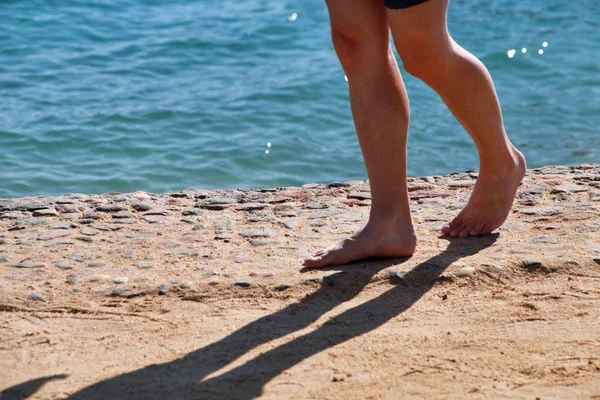 Man legs on sand. Male feet walking on beautiful sandy beach of hotel resort on Red sea in Egypt, doing and leave behind footprints in sand. Man on vacation in summertime. Travel and holiday concept. — Stock Photo, Image