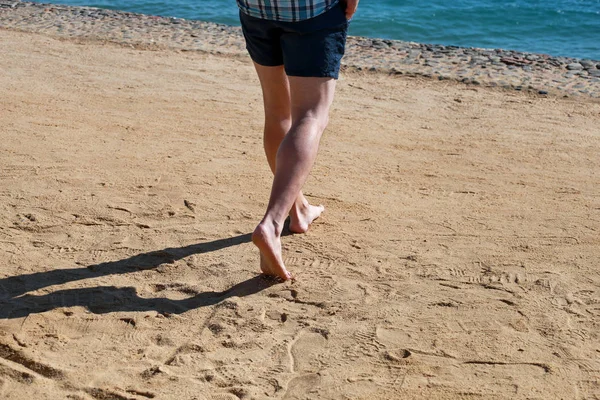 Kumda erkek bacakları. Erkek ayakları Mısır'da Kızıldeniz'de otel tesisi güzel kumlu plajda yürüyüş yapıyor ve kum ayak izleri geride bırakın. Yaz ları tatilde olan adam. Seyahat ve tatil konsepti. — Stok fotoğraf