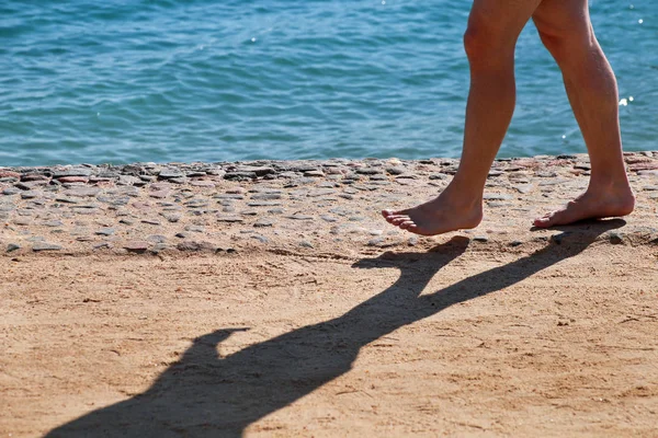 Man legs on sand. Male feet walking on beautiful sandy beach of hotel resort on Red sea in Egypt, doing and leave behind footprints in sand. Man on vacation in summertime. Travel and holiday concept. — Stock Photo, Image