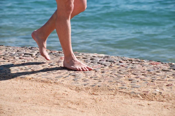 Man legs on sand. Male feet walking on beautiful sandy beach of hotel resort on Red sea in Egypt, doing and leave behind footprints in sand. Man on vacation in summertime. Travel and holiday concept. — Stock Photo, Image