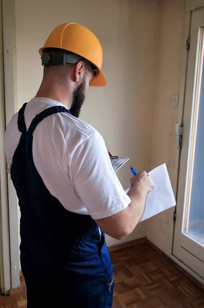 Ingeniero, contratista o gerente de proyecto con la construcción de documentos está comprobando el sitio de construcción. Supervisor en habitación para renovación con plano de apartamento y construcción de interiores de planta conceptual . — Foto de Stock