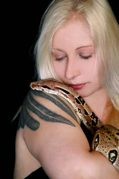 Portrait of girl with Boa constrictor snake. Beautiful woman holds snake in hands and posing in front of camera. Exotic tropical cold blooded reptile, non poisonous Boa constrictor species of snake. — Stock Photo, Image