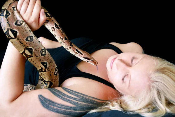 Portrait of girl with Boa constrictor snake. Beautiful woman holds snake in hands and posing in front of camera. Exotic tropical cold blooded reptile, non poisonous Boa constrictor species of snake. — Stock Photo, Image