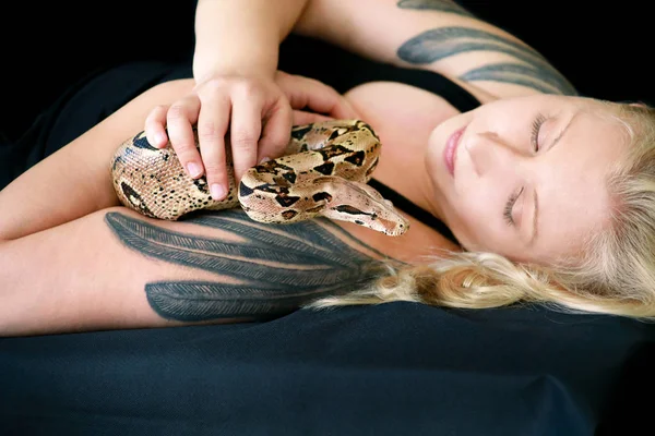 Portrait of girl with Boa constrictor snake. Beautiful woman holds snake in hands and posing in front of camera. Exotic tropical cold blooded reptile, non poisonous Boa constrictor species of snake. — Stock Photo, Image