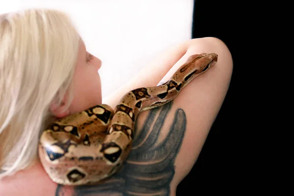 Snake on female shoulder and hand, part woman naked body. Non poisonous Boa constrictor species of snake slithering and crawling per woman hand, shoulder. Exotic tropical cold blooded reptile animal. — Stock Photo, Image