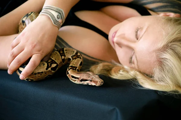 Portrait of girl with Boa constrictor snake. Beautiful woman holds snake in hands and posing in front of camera. Exotic tropical cold blooded reptile, non poisonous Boa constrictor species of snake. — Stock Photo, Image