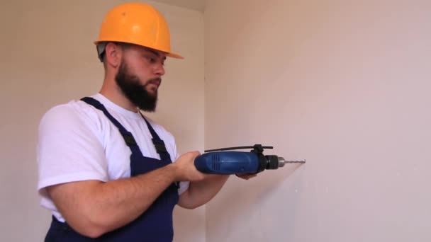 建筑工人和杂工在公寓的装修工作 施工者用蓝色电钻钻进建筑工地的墙壁上打一个钉子孔 房屋装修概念 建筑工具 — 图库视频影像