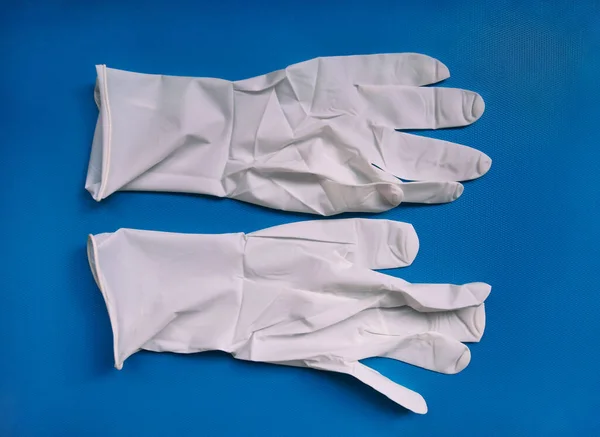 蓝色背景的医用白乳胶防护手套 防止病毒 头孢病毒 Covid 细菌传播的防护一次性手套 保健和外科概念 — 图库照片