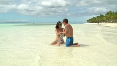 Erkek ve kadın birbirlerini denizde su sıçramasına