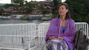 Bir kadın ve bir tekne yelken kulaklıklar müzik dinler