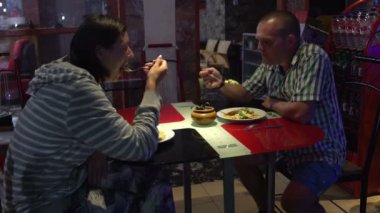 Bir erkek ve bir kadın bir restoranda oturan ve Cap cay yemek