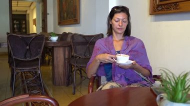 Bir kafede bir masada otururken kahve içme kadın