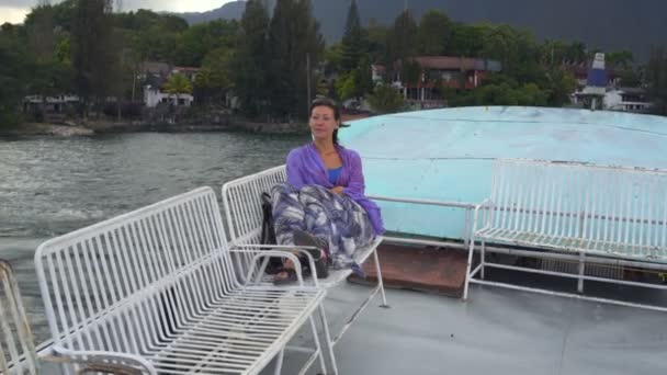 Una mujer está montando un barco en un lago — Vídeos de Stock