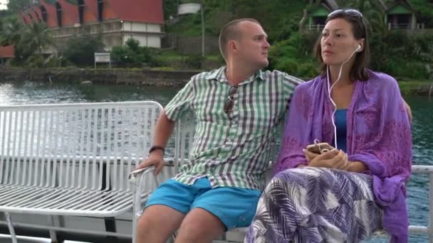 Un hombre con una mujer nada en el lago en un barco — Vídeo de stock