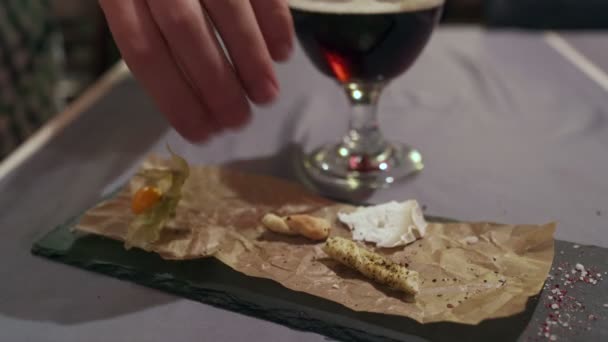 Mens mano toma palitos de pan cerca es un vaso de cerveza — Vídeos de Stock