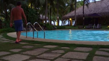 Açık yüzme havuzu ve bir sürüklenir merdivenlerden adam