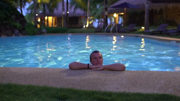 The male in the evening at the outdoor swimming pool — Stock Video