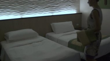 Hizmetçi bir otel odasında yatağın arkasında. Bölüm 1