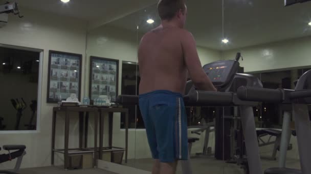 L'homme sur le tapis roulant au gymnase — Video