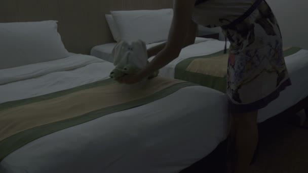 Pokojówka stawia bunny ręcznik na łóżko w pokoju hotelowym — Wideo stockowe