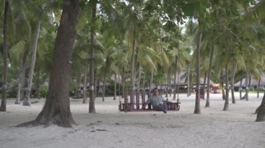 Avuç içi arasında sokakta bir salıncak üzerinde sallanan bir adam