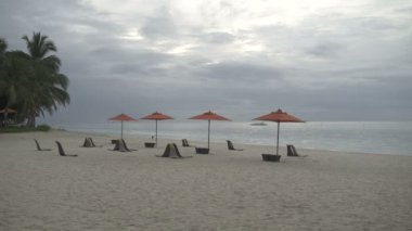 Sahilde deniz kenarında şezlong şemsiye ile stand