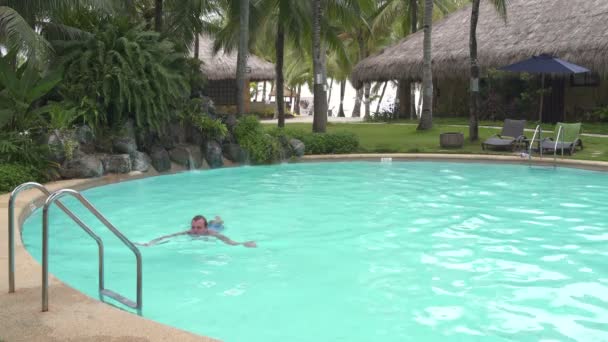 El hombre nada hasta las escaleras de la piscina al aire libre y va — Vídeo de stock