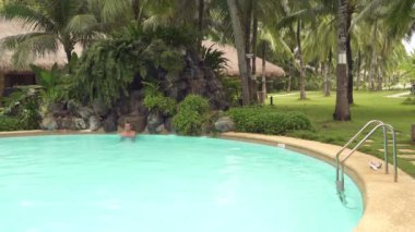 Açık Yüzme havuzunda şelale altında bir adam rahatlatır