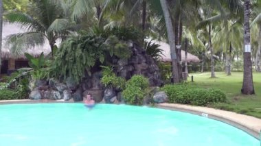 Açık Yüzme havuzunda bir şelale altında bir adam duruyor