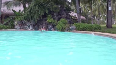 Açık Yüzme havuzunda yapay şelale altında bir kadın soğur