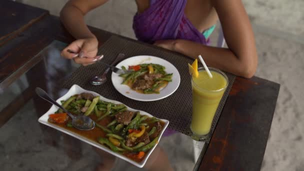 Uma mulher em um restaurante comendo carne com legumes — Vídeo de Stock