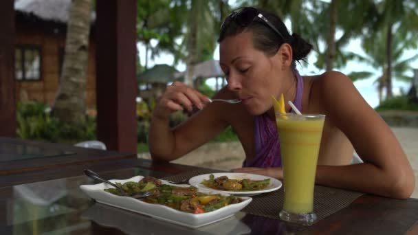 デスクの女性の背後にある通りのレストランは野菜と肉を食べる — ストック動画