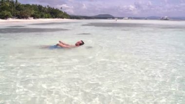 Adam arkasına denizde yüzüyor