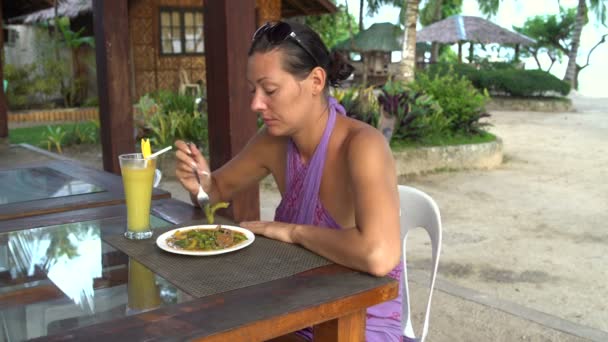 Chica en el café al aire libre se sienta a la mesa y comer — Vídeos de Stock