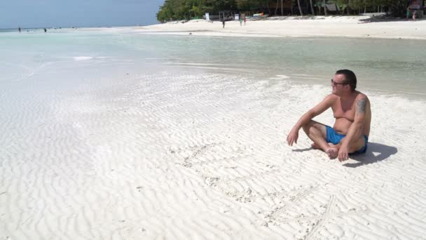 Ein Mann entspannt sich am Strand — Stockvideo