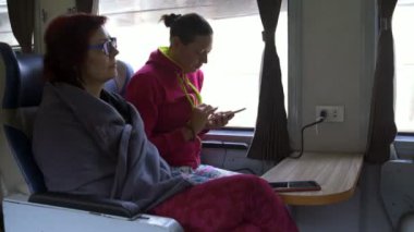 Kadın trende gidin ve akıllı telefonlar kullanın