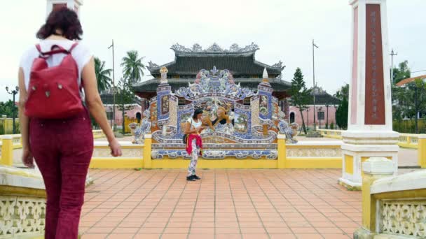 Kvinnor stå bredvid ett buddhistiskt tempel och prata — Stockvideo