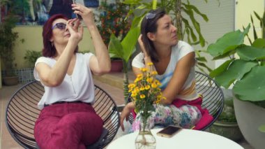 Kadının resmi kafede oturan smartphone için yapması