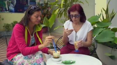 Sokakta bir restoranda, kadınlar bir saman kahve içmek.