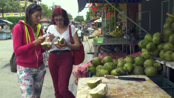 Mulheres comem colher de coco na rua — Vídeo de Stock